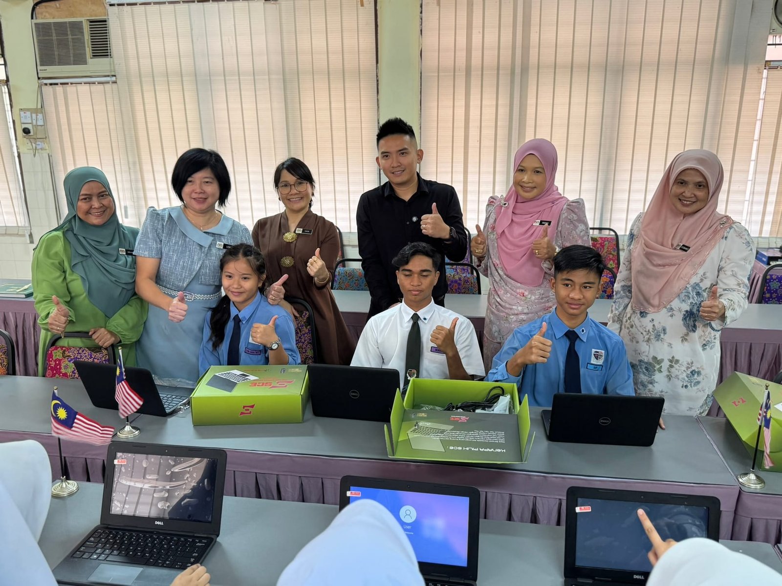 Boss A with students and teachers receiving laptops